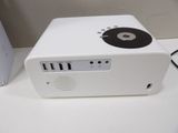 a small white projector sitting on a table next to a computer