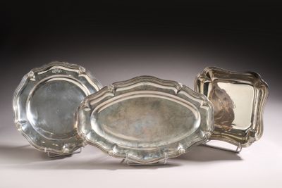 three silver trays sitting next to each other on a table