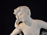 a statue of a woman sitting on top of a table