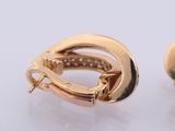 pair of yellow gold hoop earrings with diamonds on a white surface