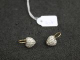 un gros plan sur une paire de boucles d'oreilles et une étiquette posées sur une table