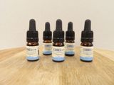 trois flacons d'huile de CBD posés sur une table en bois