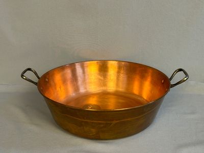 an old copper pan with handles and handles on a white background
