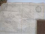 an old map of the americas with a leather case on a table