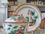a bowl with a lid and a plate with a picture on it