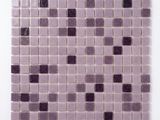 un gros plan sur un carreau de mosaïque violet posé sur une surface blanche
