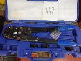 une caisse à outils bleue avec des outils sur le sol