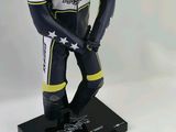 statue of a man in a racing suit standing next to a card