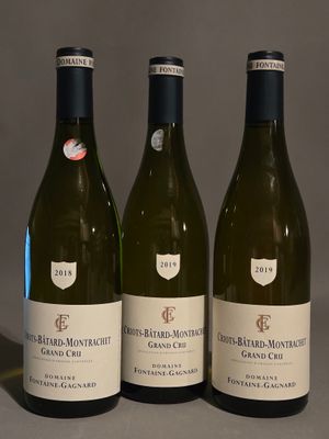 trois bouteilles de vin posées sur une table l'une à côté de l'autre