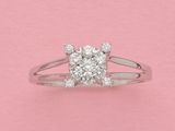 un gros plan d'une bague en diamant sur fond rose
