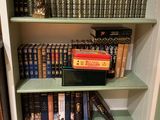 a book shelf with many books on it in a room