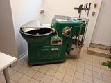 une machine verte posée dans une cuisine, à côté d'une poubelle