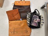 many bags and purses on the floor next to each other