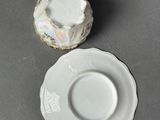 a small white plate and saucer sitting on a table