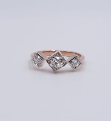 une image représentant une bague en diamant à trois pierres sur fond blanc