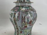 a vase with a lid that has a painting on it