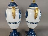 pair of blue and white vases with gold handles on stands