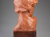 a sculpture of a woman ' s head on a wooden base