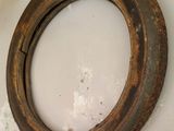 a rusted tire on the floor next to a wall