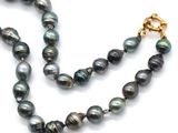 the necklace is made of black pearls and a gold clasp