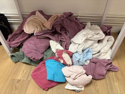 a pile of clothes on the floor next to a table