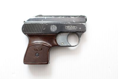 un pistolet posé sur une surface blanche