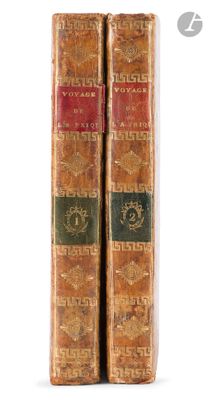 two old books sitting on top of each other on a white surface