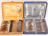 two boxes with silverware in them on a white surface