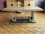 une table en bois avec un piètement en métal posée sur un parquet en bois dur