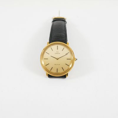 une photo d'une montre-bracelet plaquée or avec un bracelet en cuir noir