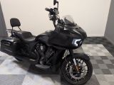 une moto noire garée sur un sol à damier