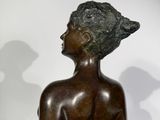 statue of a woman with a hat on her head sitting on a table