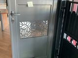 a metal door with a green carpet on the floor