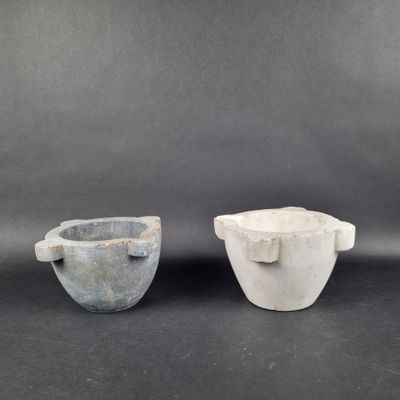 two white and gray bowls sitting next to each other on a black surface