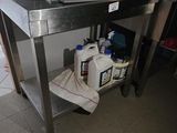 une table en acier inoxydable sur laquelle est posé un micro-ondes, dans une cuisine