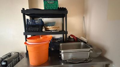 une photo d'une cuisine avec une cuisinière, un évier et des étagères