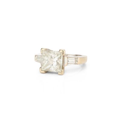 une photo d'une bague sertie d'un diamant taille princesse et de diamants taille baguette