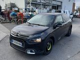 La voiture est garée sur le parking près de l'immeuble.