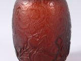 a red vase that is sitting on a white surface