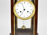 a small wooden clock with a glass case on it