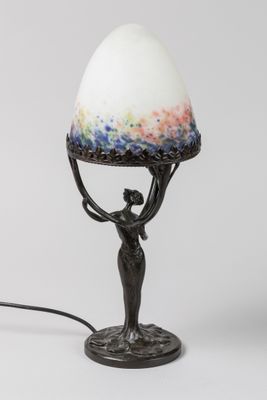 an image of a lamp with a woman holding an egg on top of it
