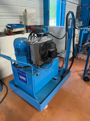 une machine bleue posée sur un chariot bleu dans un garage