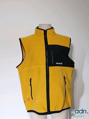 un gilet jaune et noir posé sur un présentoir à mannequin