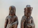 pair of carved wooden statues of a man and a woman