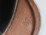 a close up of a black bowl on a table