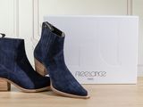 the blue sued ankle boots are next to a white box