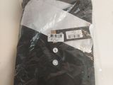 Le t-shirt est noir et blanc, avec une bande blanche dessus.