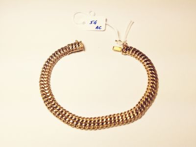 a close up of a gold chain bracelet with a tag on it