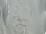 a close up of a glass vase with a face on it