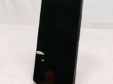 the back of a black cell phone sitting on top of a white table